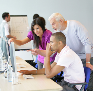 Session de formation professionnelle devant écrans d'ordinateur