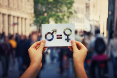 Deux mains tenant une affichette symbolisant égalité femme homme et parité