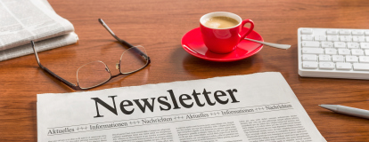 Un journal posé sur une table à côté d'une tasse de café et d'une paire de lunettes