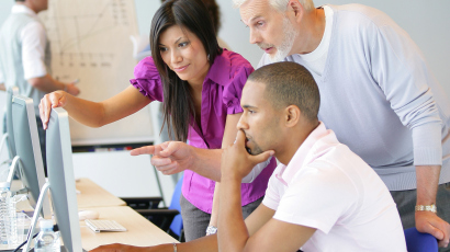 Session de formation professionnelle devant écrans d'ordinateur